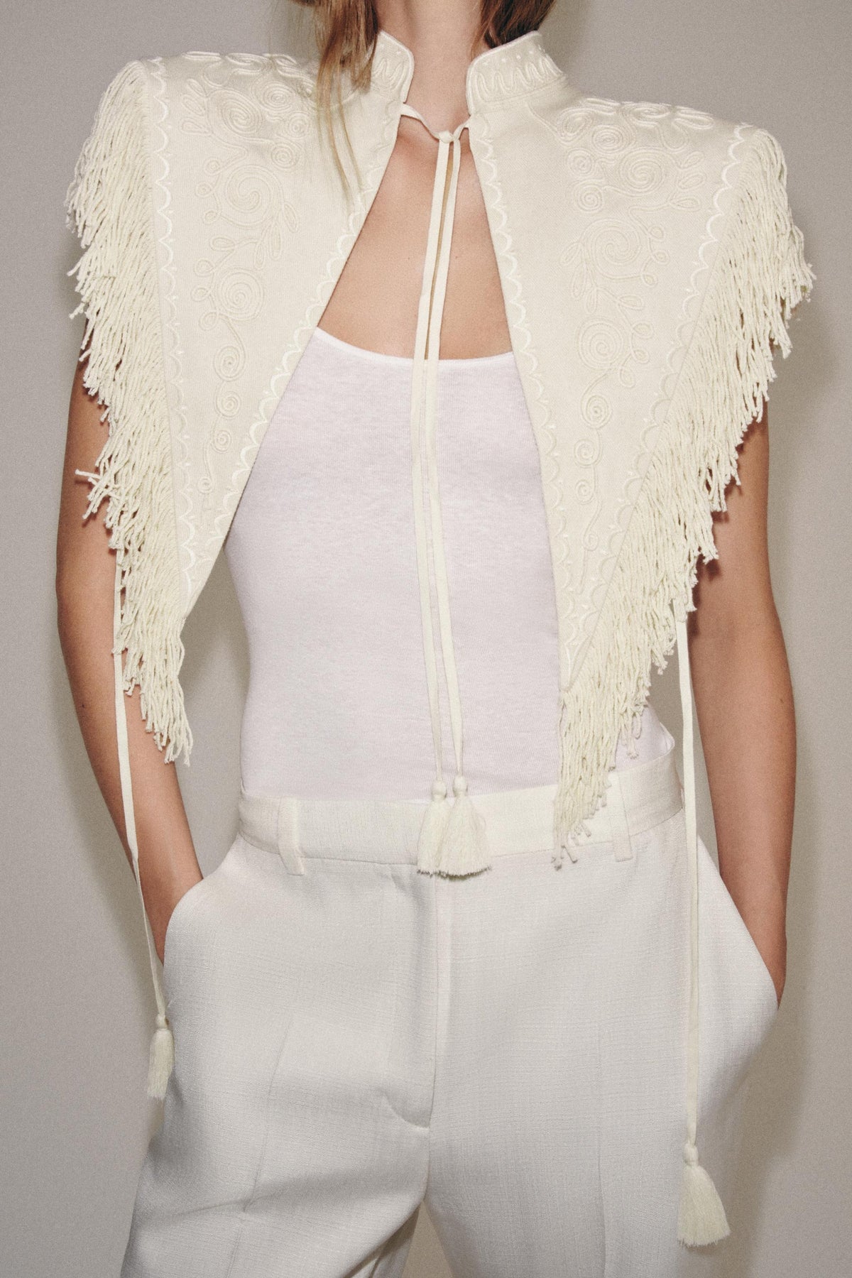 Gilet corto color crema ricamato con frange