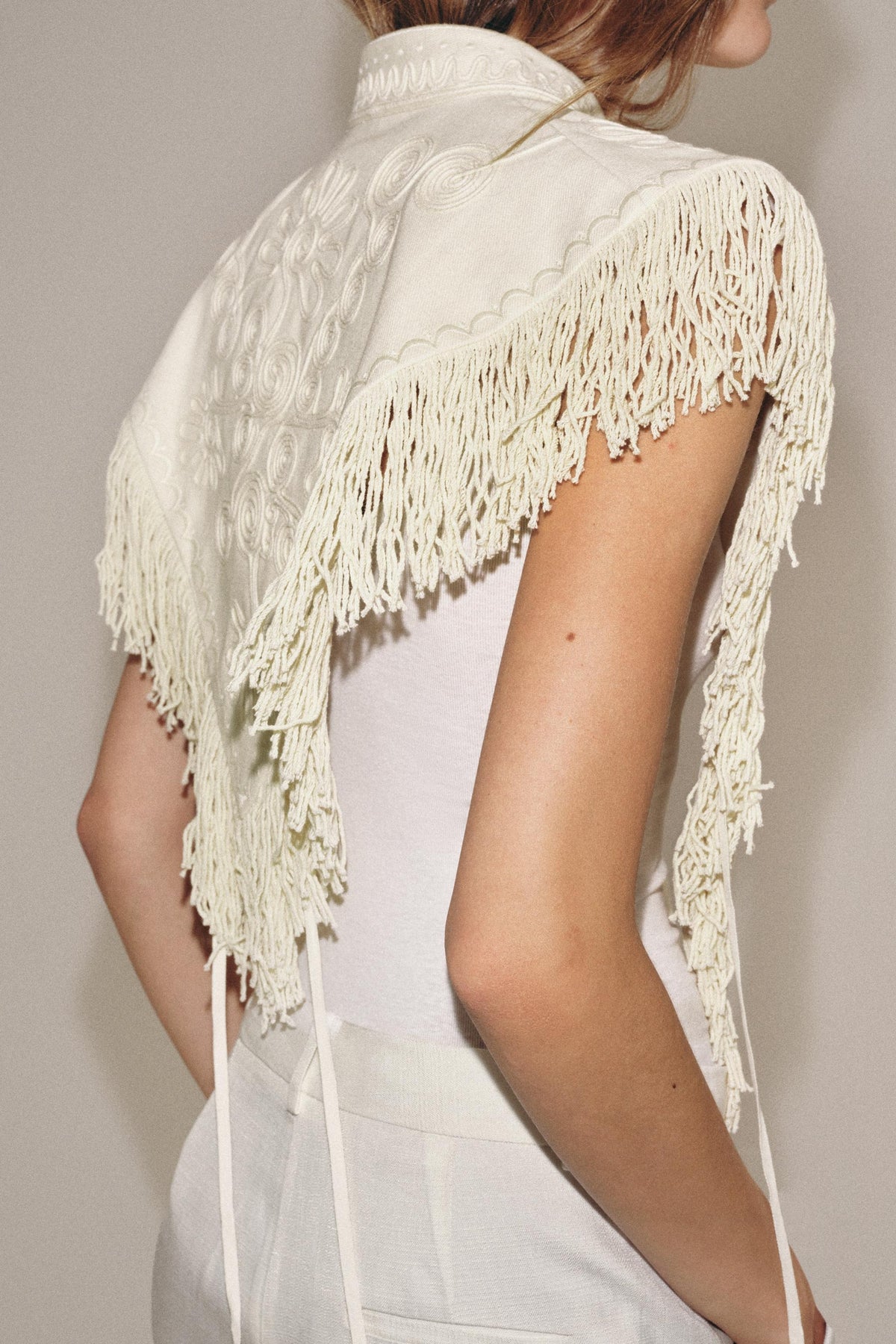 Gilet corto color crema ricamato con frange
