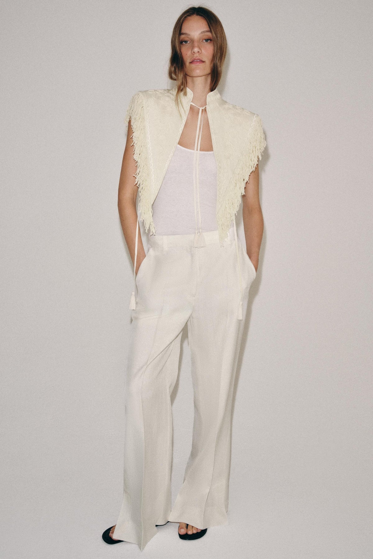 Gilet corto color crema ricamato con frange